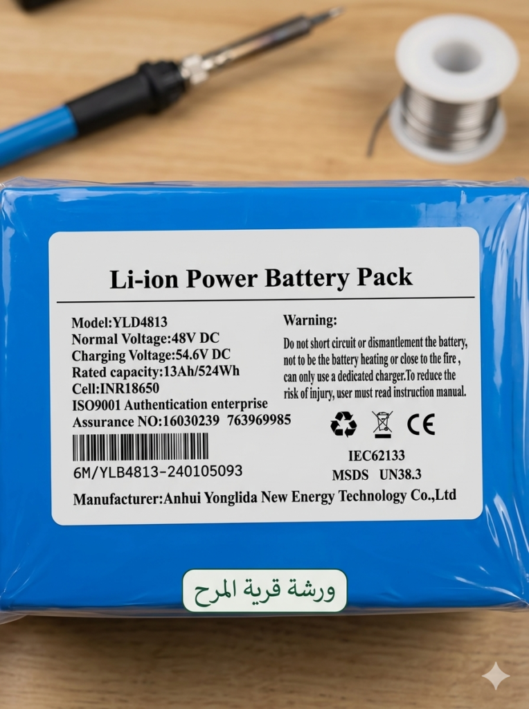 "حزمة بطارية ليثيوم أيون 48 فولت (طراز YLD4813) مع ملصق المواصفات الفنية، تظهر خلفية لعملية الصيانة مع كاوية لحام، خدمة احترافية من ورشة قرية المرح."